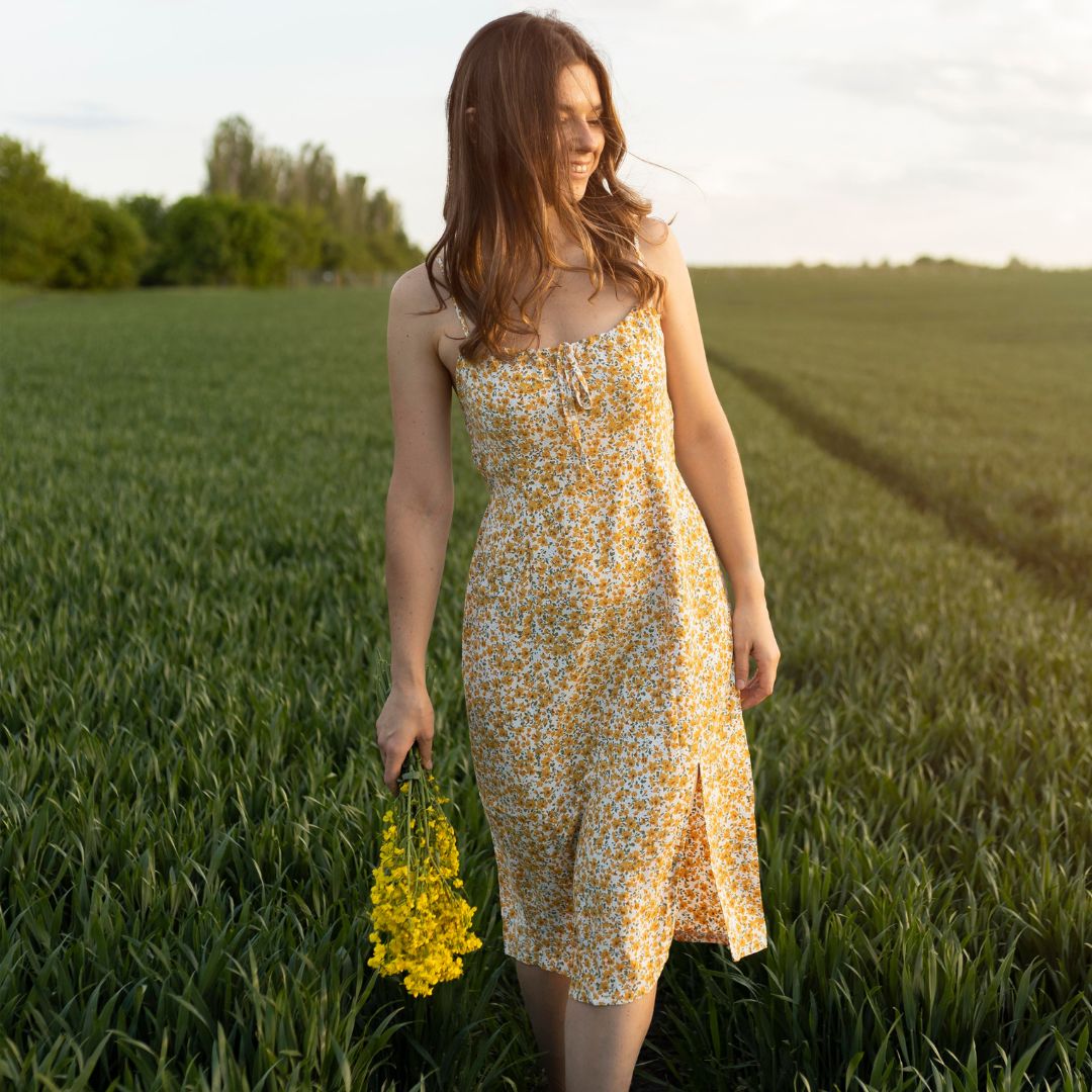 Woman in elegant floral midi dress at green field — Emmie & Ellie midi dresses